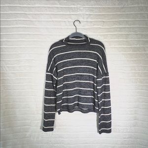 A stripped grey and white turtle neck sweater.